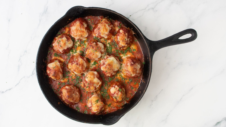 Chicken parmesan meatball skillet garnished with parsley