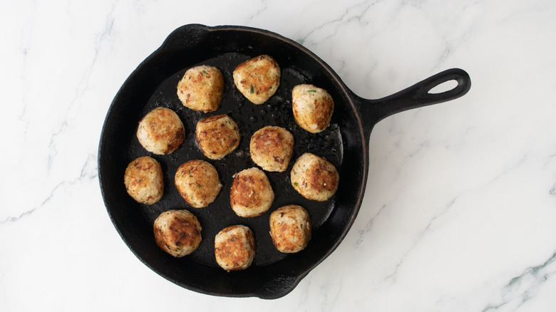 Seared chicken meatballs in skillet