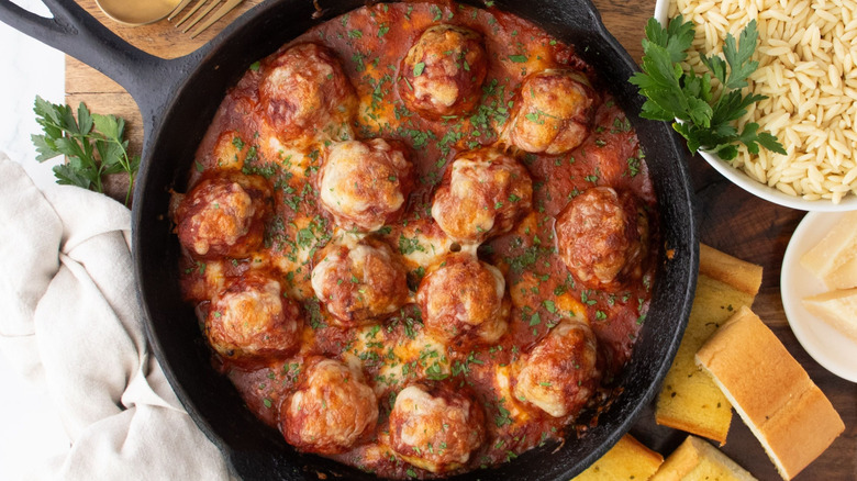 Chicken parmesan meatball skillet garnished with parsley