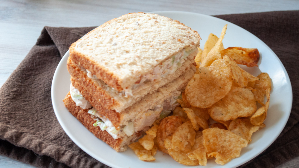 Chicken salad sandwich and chips on plate