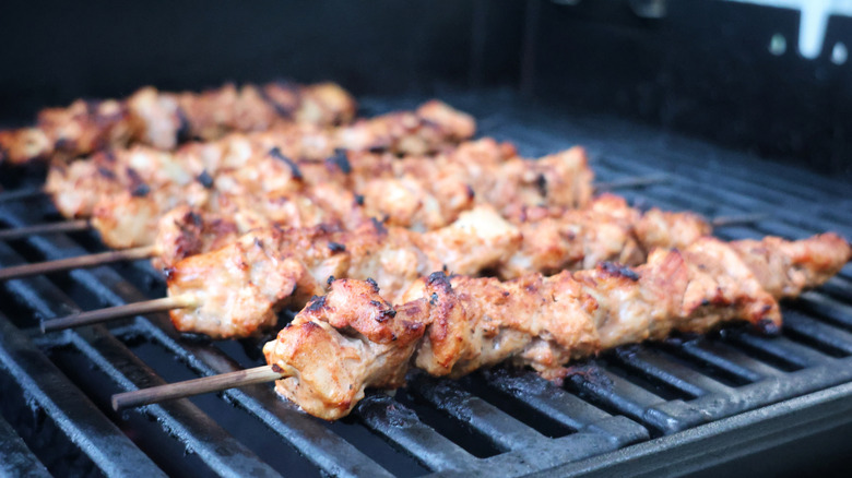 chicken kebabs cooking on the grill