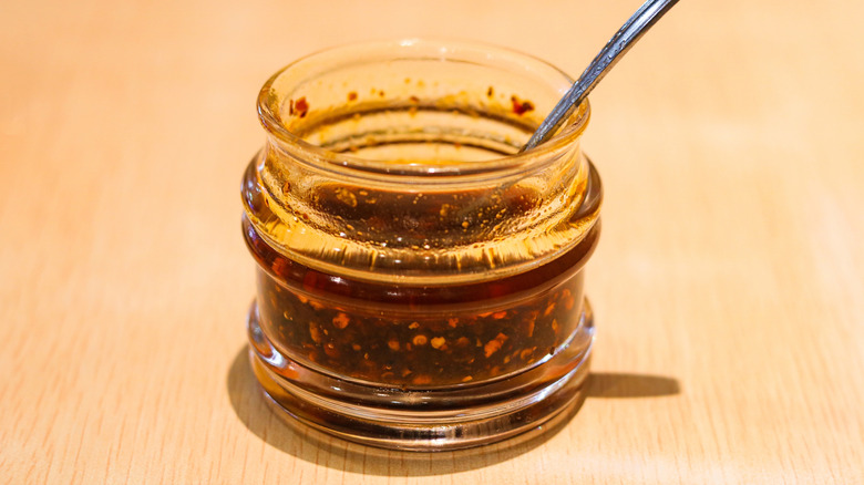 Glass jar of chili crisp with spoon