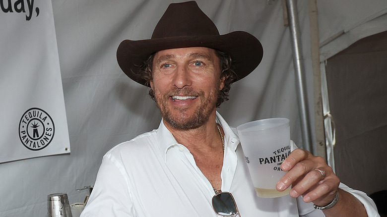 Matthew McConaughey holding up glass