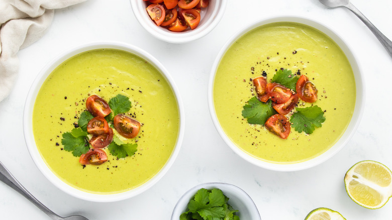 two bowls of avocado soup with garnish