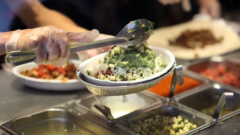 worker making Chipotle burrito bowl