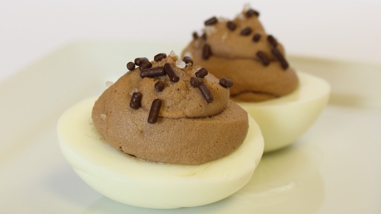 two chocolate deviled eggs with chocolate sprinkles on top