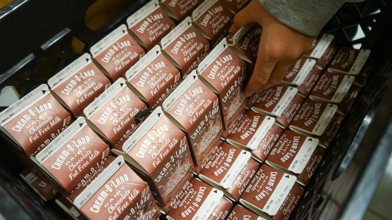 hand selecting chocolate milk carton