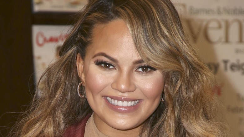 Chrissy Teigen smiling with hair down