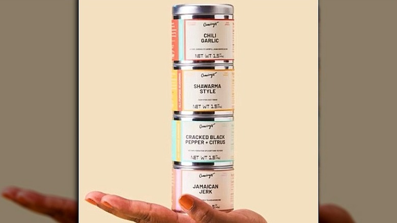 4 spice canisters stacked in a hand