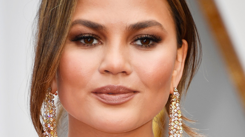 Chrissy Teigen in closeup wearing earrings