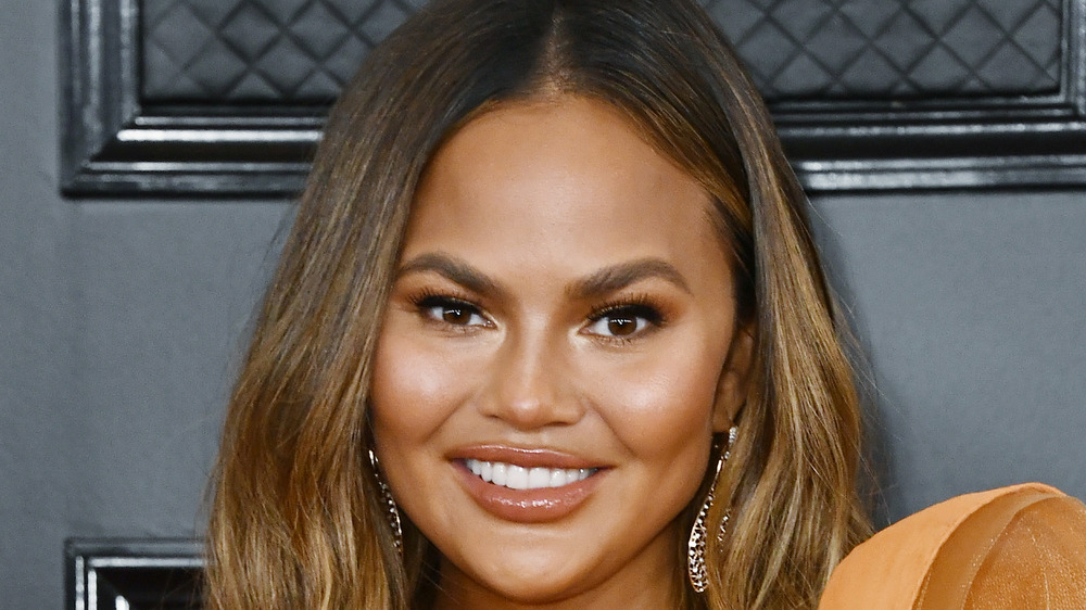 Chrissy Teigen in an orange dress