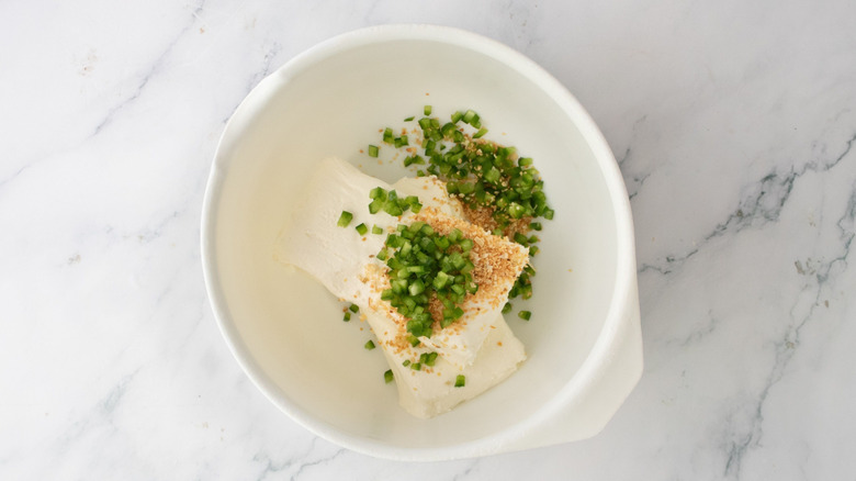 Cream cheese, jalapeño, and seasonings in bowl