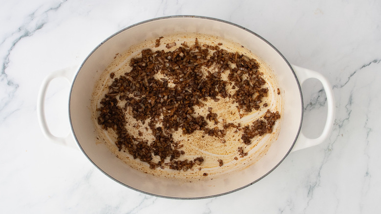 Spice coated minced onion and garlic in pot