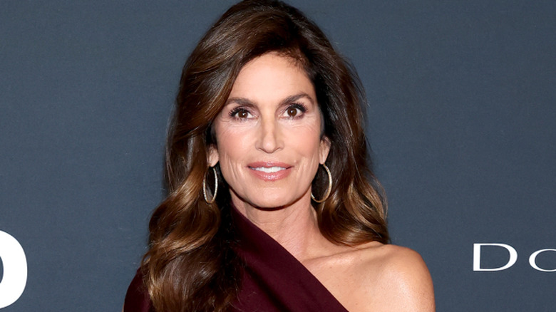 Cindy Crawford smiling for cameras at publicity event.