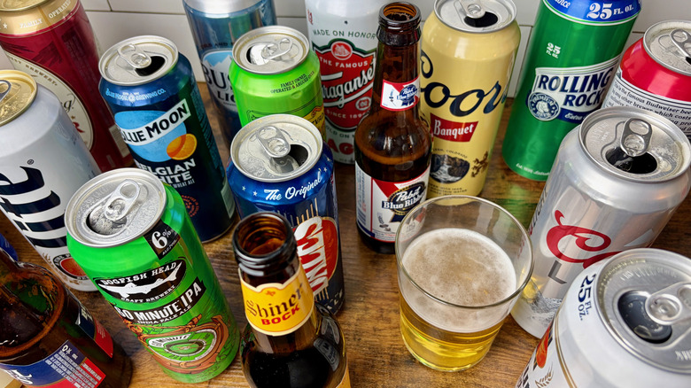 Tasting 18 open cans and bottles of beer and a half full glass of beer in the center