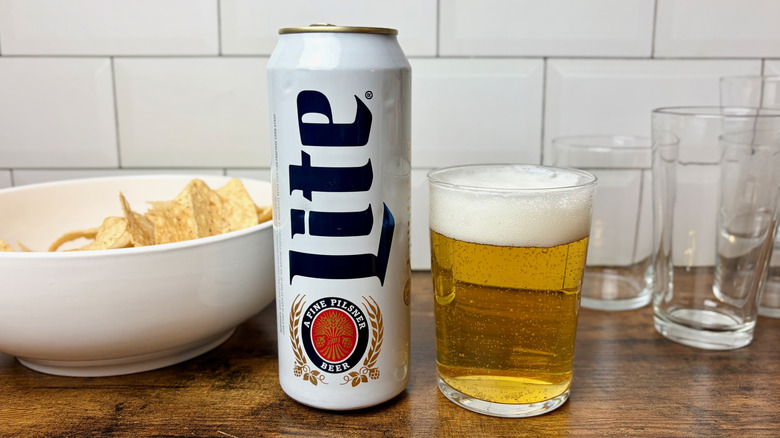 A white can of Miller Lite beer beside a glass of beer