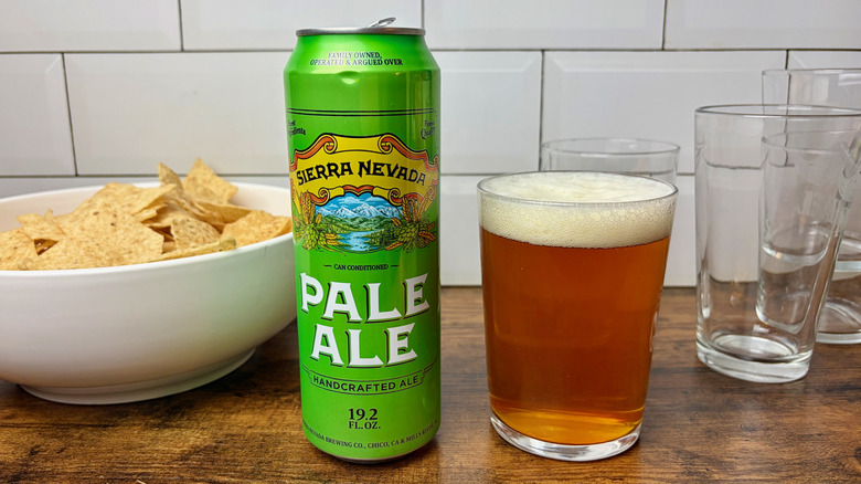 A green can of Sierra Nevada next to a full glass of beer