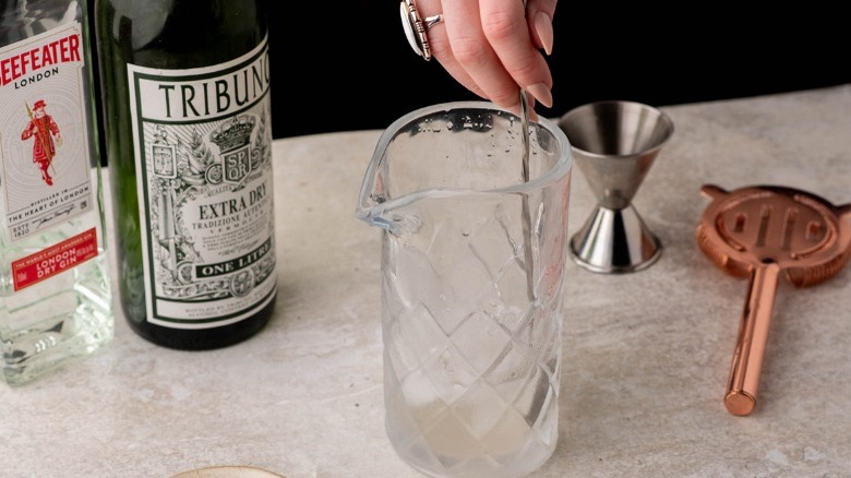 stirring martini ingredients in glass