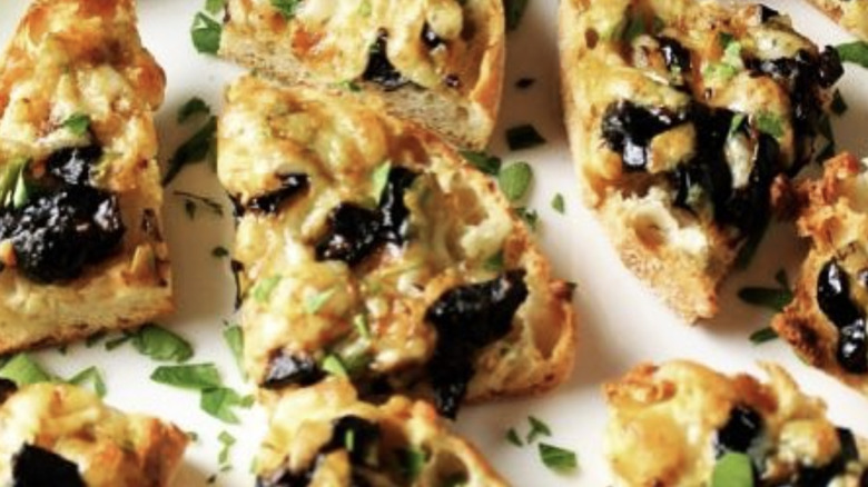 Quartered English muffins with black olives and herbs