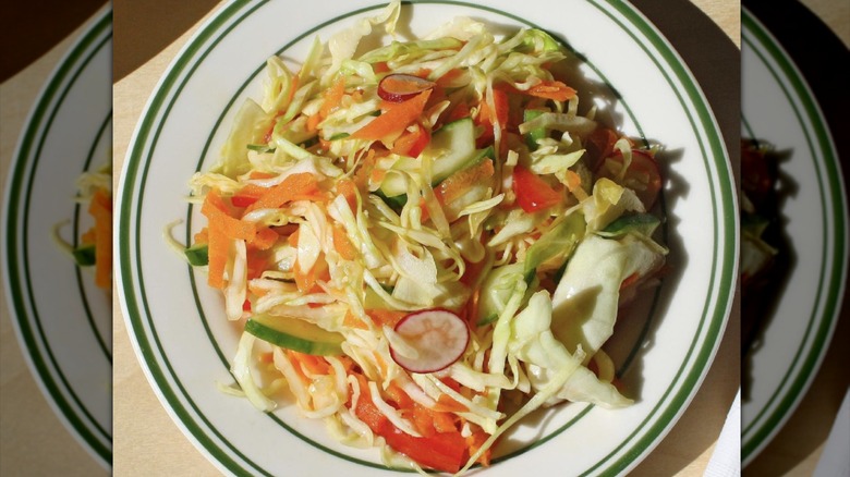 Bowl of shredded cabbage salad with assorted vegetables