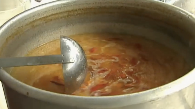 Large pot of broth with peppers