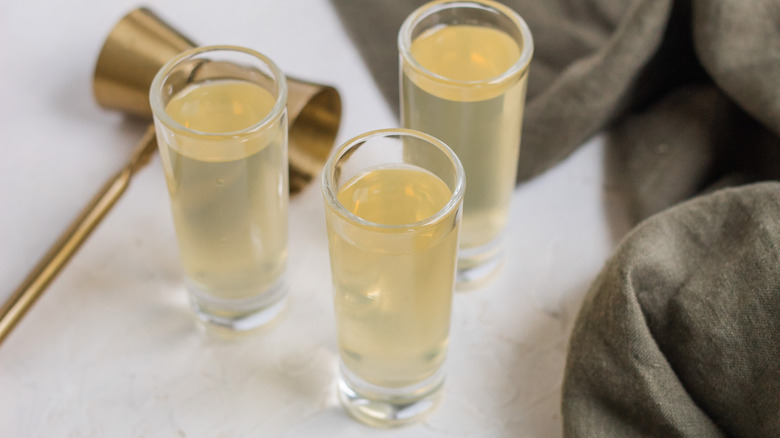 a trio of shot glasses with liquid