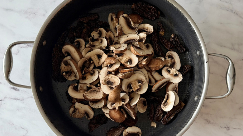 Sliced cremini and morel mushrooms in skillet
