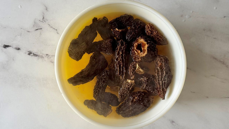 Morel mushrooms and water in bowl