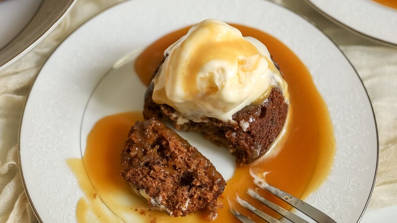 Sticky toffee pudding with bite separated by fork on plate