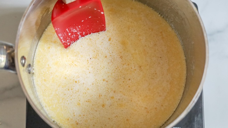 Butter and cream sauce in saucepan with rubber spatula