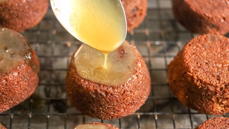 Spooning toffee sauce onto sticky toffee pudding