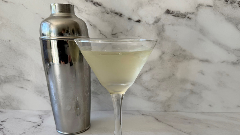 Martini in glass in front of cocktail shaker