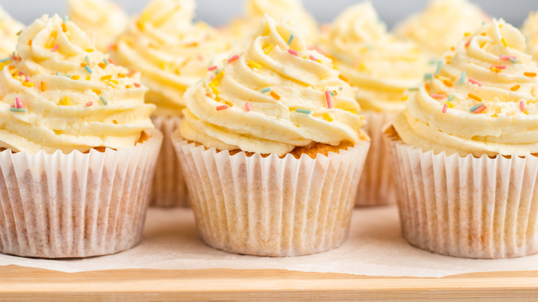 vanilla-frosted cupcakes on board