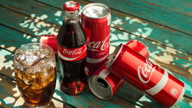Coca-Cola cans, bottle, and drink glass