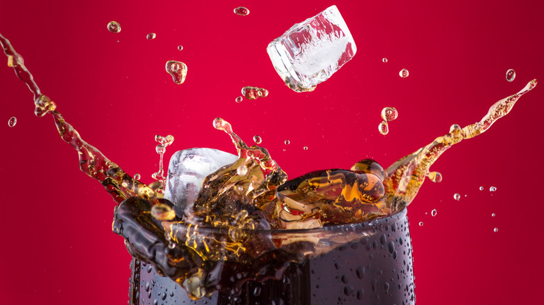 coke and ice splashing in glass