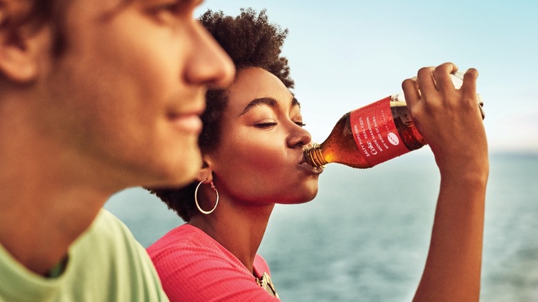 Person drinking Coke bottle with poem