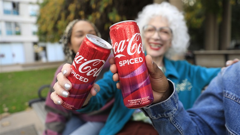 People with Coca-Cola Spiced cans