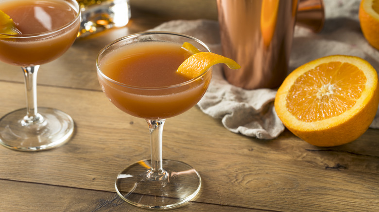 Blood and Sand cocktails on wood table next to orange