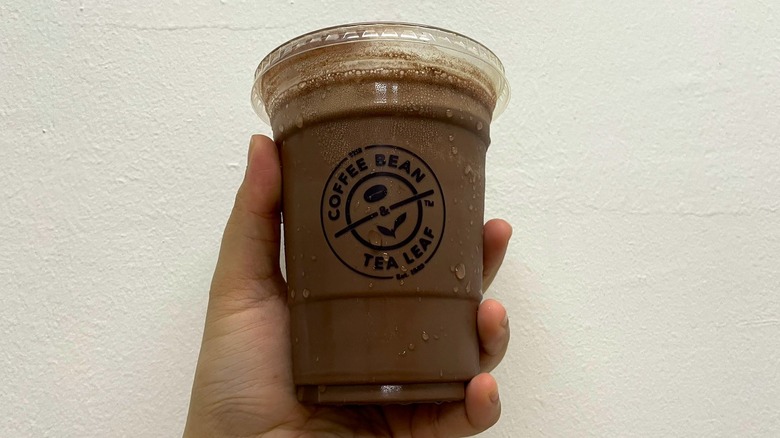 person holding iced coffee bean drink