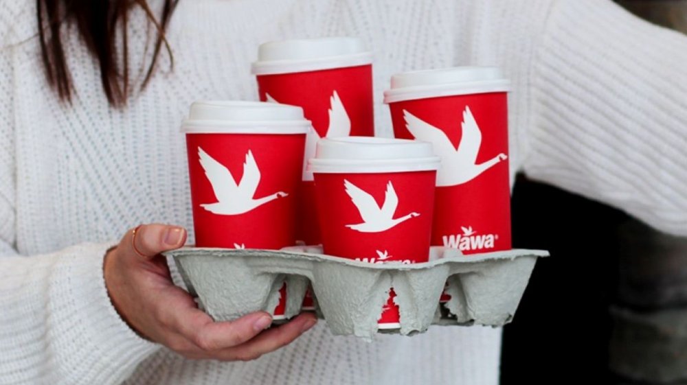 Person carrying Wawa coffee cups in multiple sizes