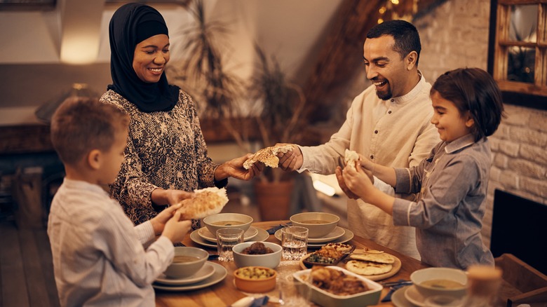 Happy Muslim family eating dinner.