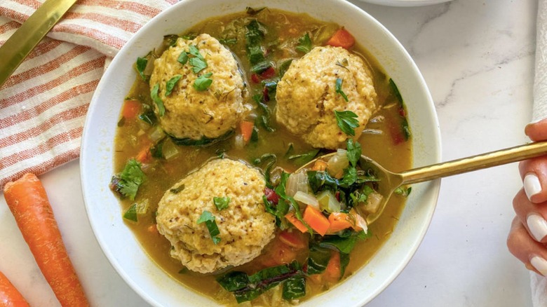 matzo ball soup with gold spoon