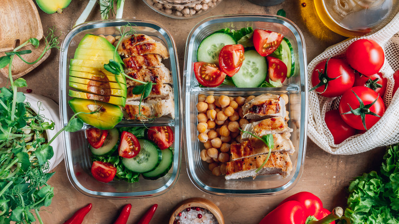 Clear meal containers with veggies, chicken, and avocado. 