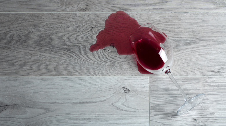 Glass of wine knocked over with wine spilled