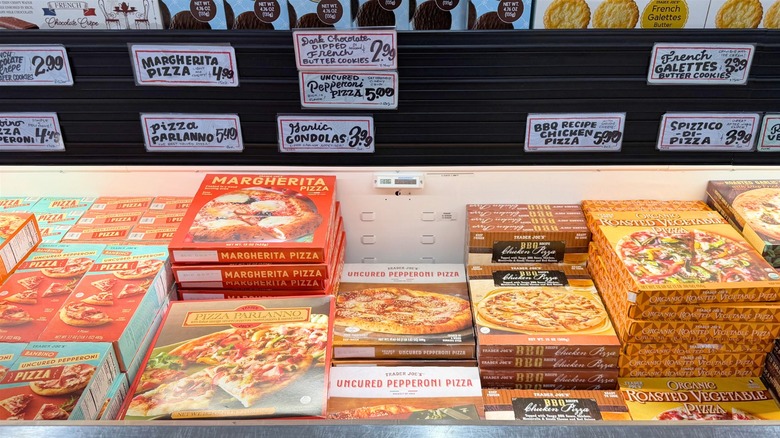 Frozen pizzas in refrigerator case at Trader Joe's.