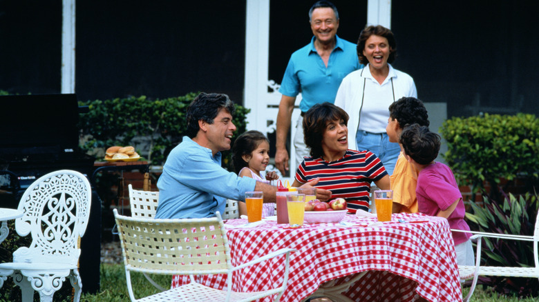 A multigenerational family enjoying a 1970s cookout