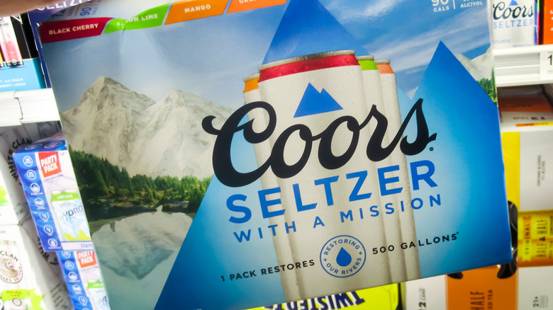 Person holding case of Coors seltzer