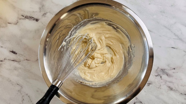 Whisked chicken salad dressing in bowl