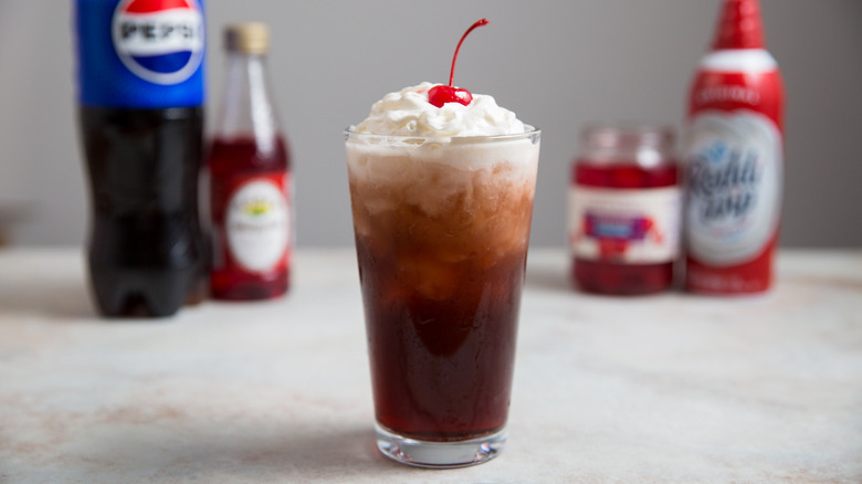 dirty soda served on table with ingredients in background