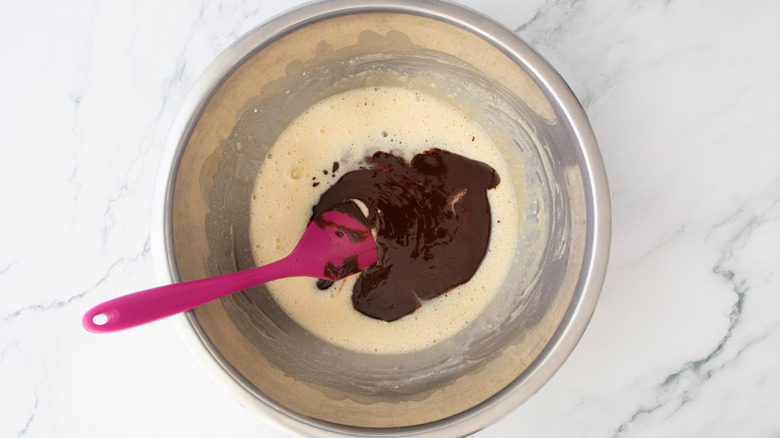 melted chocolate and cake batter in a metal bowl
